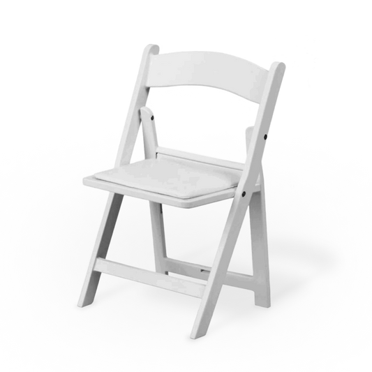 A child-sized white resin folding chair on a grassy lawn