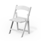 A child-sized white resin folding chair on a grassy lawn